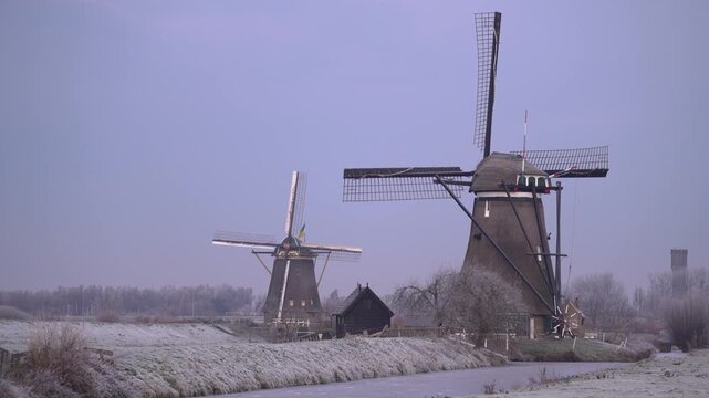 Iconic Dutch Windmills of Kinderdijk in a Frosty Frozen Winter Landscape.