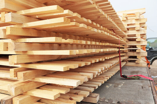 Delivery of boards and lumber. Boards loaded onto a truck. Transportation of finished products by truck. Lumber for pallet production