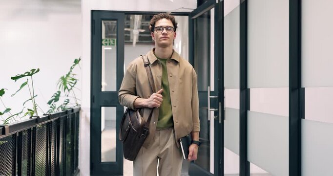 Creative, face and businessman walking in office building for work arrival or start in workplace. Portrait, man or employee with glasses, bag or book in entrance for punctuality or time management