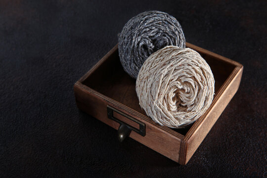 Wool tweed yarn for knitting in skeins is in wooden box. Yarn for knitting or crocheting. Handmade work. Hobby concept. Copy space