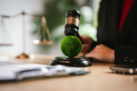 Judge's gavel above a green globe symbolizing environmental law, ESG compliance, climate justice, and sustainable governance.