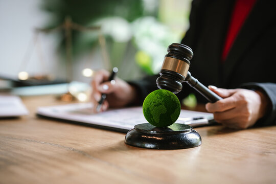 Judge's gavel above a green globe symbolizing environmental law, ESG compliance, climate justice, and sustainable governance.