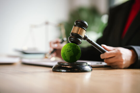 Judge's gavel above a green globe symbolizing environmental law, ESG compliance, climate justice, and sustainable governance.