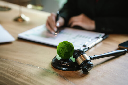 Judge's gavel above a green globe symbolizing environmental law, ESG compliance, climate justice, and sustainable governance.