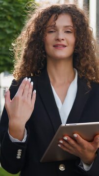 Caucasian business woman using digital tablet device gadget looking at camera invite showing welcoming gesture in city businesswoman female girl agent working with wireless computer inviting come here
