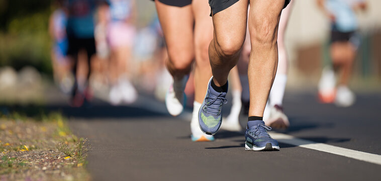 Marathon running race, people feet on city road, runners run urban marathon in the the city	