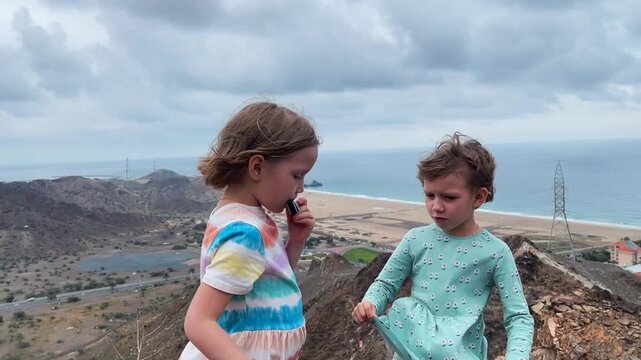 Children play the harmonica on the mountain trail