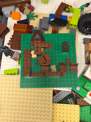 Fototapeta premium Pile of lego bricks and base plates scattered around a green building board