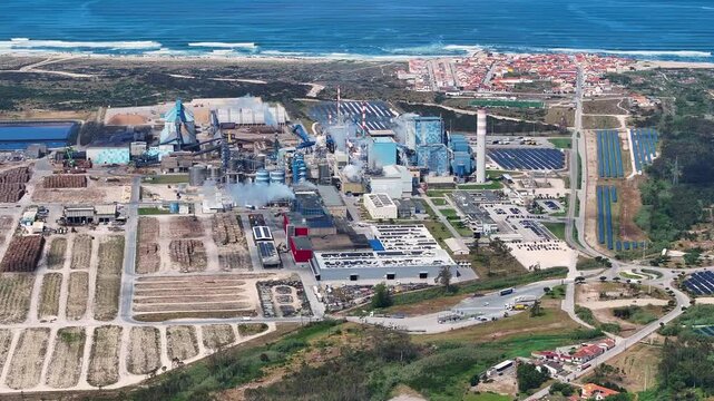 Aerial view of industrial pulp mill and solar panel farm