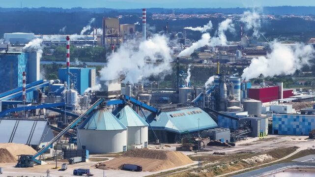 Industrial pulp and paper mill emitting steam and smoke