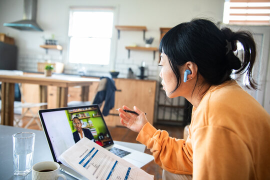 Woman on video call working from home at kitchen table