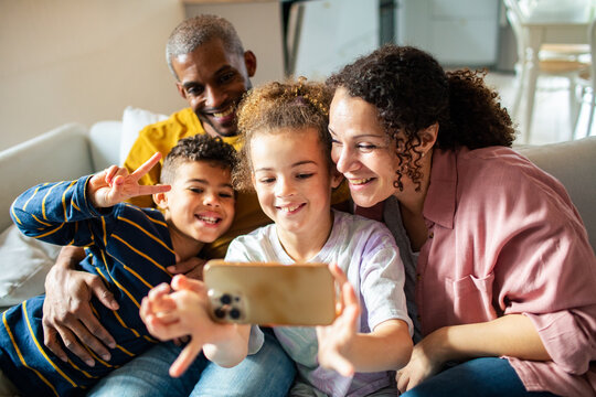 Happy family taking smartphone selfie at home