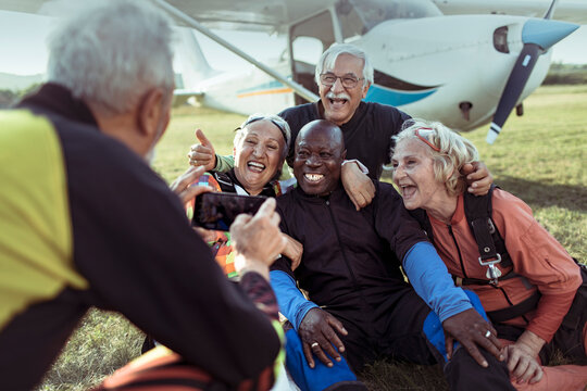 Group of senior skydivers celebrating at airfield