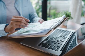 ESG report corporate compliance reporting concept close up hands typing on laptop keyboard and holding environmental sustainability document for business governance data entry at office desk © HappyEva