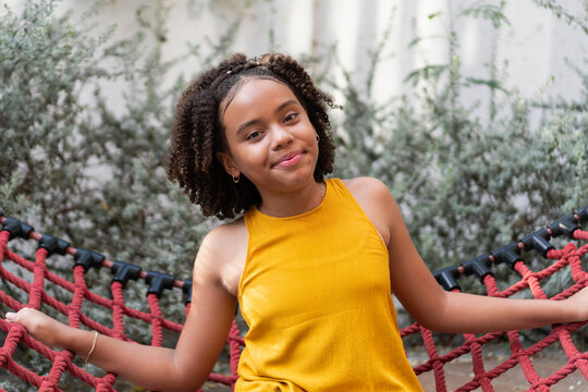 Happy young girl relaxing in a red hammock outdoor