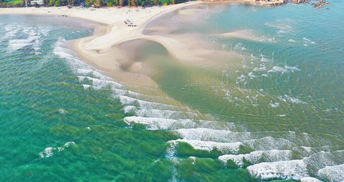 Stunning aerial view of Ke Ga Bay, Vietnam, showcasing turquoise waters, curved sandbars, gentle waves and a pristine coastline.