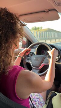 Woman driving car, highway travel adventure. Static interior shot.