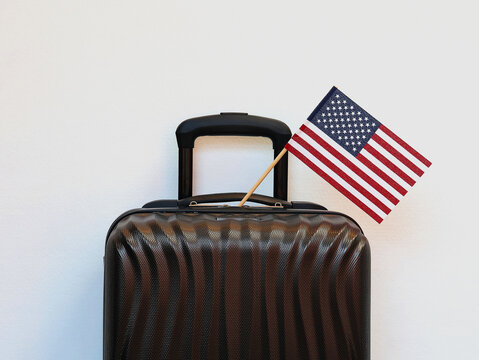 Close-up of a suitcase with the American flag, isolated against a white background.