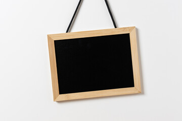 Blank blackboard with wooden frame hanging on white wall. Template mockup © Formatoriginal