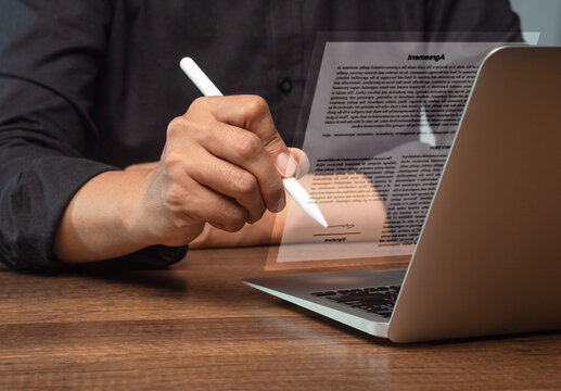 Person Signing Digital Agreement with Stylus and Laptop