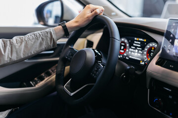 Naklejka premium man driving car. Hands on Steering Wheel Driving a Car. male hands on the steering wheel of a car. Man driving a car at sunset on the seashore. Auto travel concept