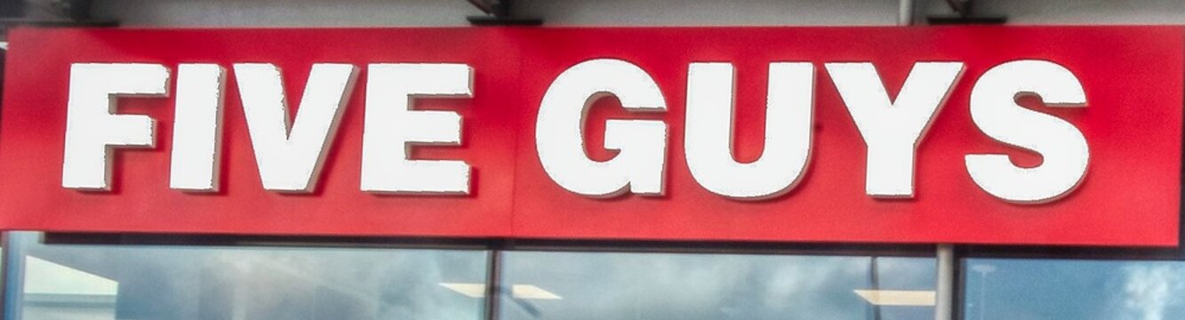 a close up photo of a  sign for five guys restaurant 