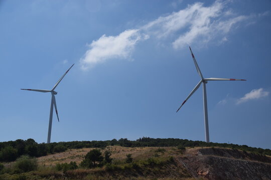 Windmills photographed against a clear sky background.
