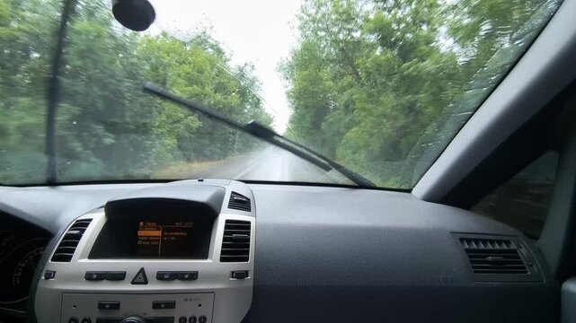 First-person view of driving on a wet highway during a heavy rainstorm. Windshield wipers are working hard. Great atmospheric POV footage for travel, road trips, and dramatic weather projects.