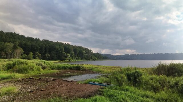 Scenic View of Buyan Lake with Forest and Dramatic Clouds in Bali