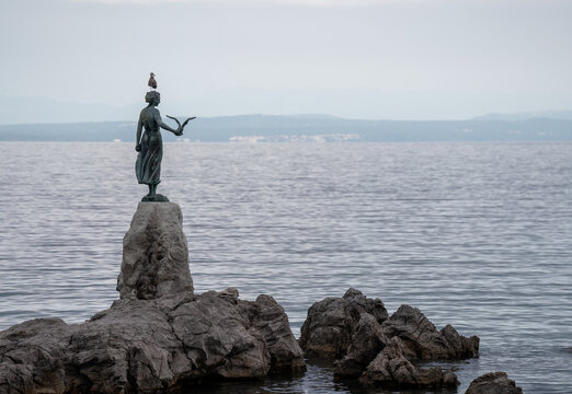 Maiden with the Seagull Statue on Rocks in Opatija Croatia Famous Bronze Sculpture Landmark Monument by Kvarner Gulf Sea Coastal Waterfront Ocean Vista
