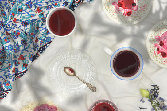 Picnic in the shade of trees in a meadow or an orchard. Kompot drink in cups. Sour cherries are floating in this drink. After drinking the kompot or while drinking it, fruit are eaten. Regional drink.