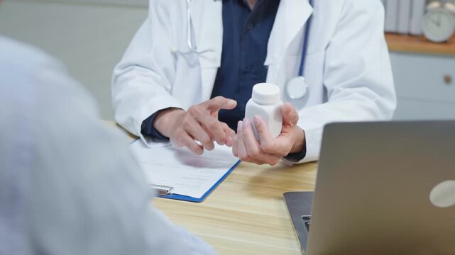 Doctor explaining treatment and medication instructions to a patient during a medical consultation in a clinic office, representing patient care, prescription guidance, healthcare service and treatmen