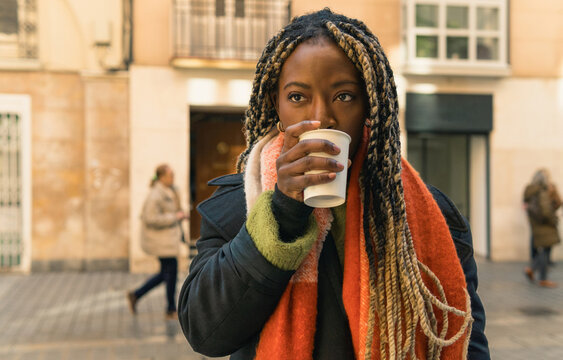 Woman drinking coffee on urban street