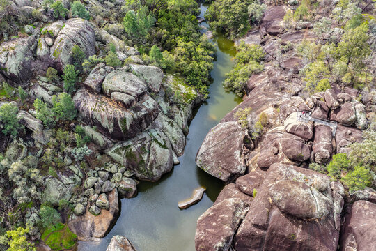 Aerial view of the natural rock pool and striking granite rock formations at Cranky Rock Nature Reserve near Warialda, NSW. Carved by Reedy Creek and surrounded by native bushland