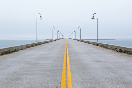 The Pier Reaches the Horizon Over a Calm Misty Sea and Sky