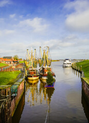 Fototapeta premium View of the harbor in Greetsiel and the surrounding nature. Landscape in East Frisia.
