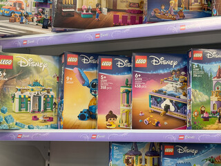 Fototapeta premium Toy store shelf filled with lego disney building set boxes on display