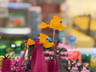 Fototapeta premium Colorful lego fish toy scene with pink coral and blurred background