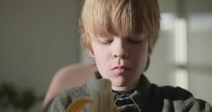 Kid Boy Eat Banana Fruit. Eating Breakfast Lunch in Kitchen. 4K 10-bit