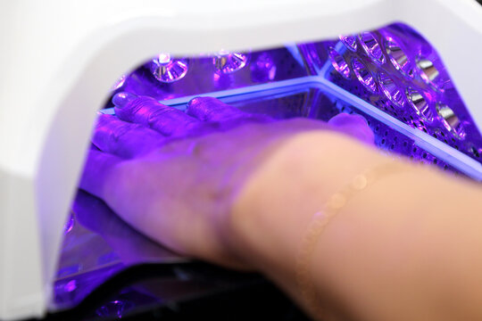 A woman's hand during a manicure. A woman getting a manicure. A manicurist is doing a client's nails at a nail salon. Manicure services. Nail art. Beauty salon.