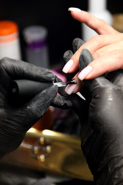 A woman's hand during a manicure. A woman getting a manicure. A manicurist is doing a client's nails at a nail salon. Manicure services. Nail art. Beauty salon.