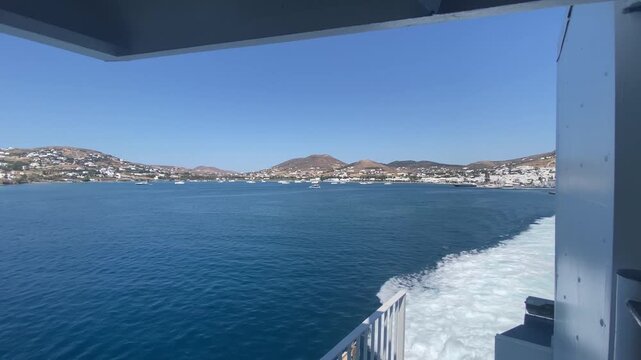 POV of a powerful sea wake from the stern of a ferry leaving Paros harbor in Greece