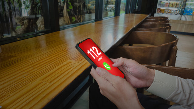 112 emergency call NOTRUF smartphone with caf&eacute; background symbolizing urgent help emergency services concept