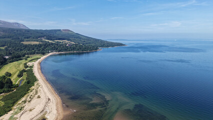 Obraz premium Brodick bay beach and coastline from above Aerial view of brodick bay beach, coastline, and clear blue water of isle of arran