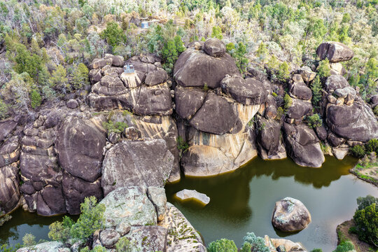 Aerial view of the natural rock pool and striking granite rock formations at Cranky Rock Nature Reserve near Warialda, NSW. Carved by Reedy Creek and surrounded by native bushland