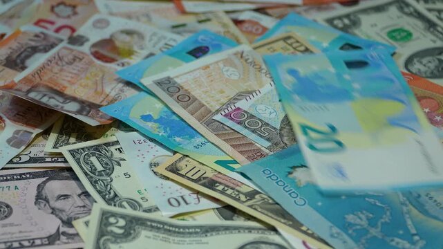 A diverse collection of international banknotes including US Dollars, Euros, and Polish Zloty falling into a pile. Cinematic slow motion shot for finance and global economy concepts.