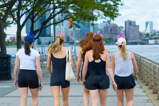 Women Wearing Colorful Tiara Headbands Walking Along New York City Waterfront