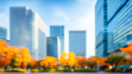 Fototapeta premium ビルと紅葉の木々に囲まれた青空広がる秋のぼかし都市風景
