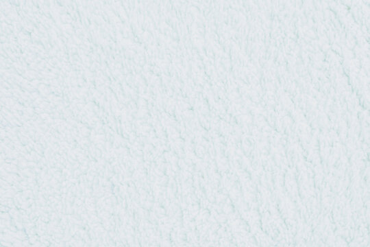 Horizontal close up of a soft fluffy white sherpa fleece textile texture showing cozy delicate plush fibers on a warm blanket or winter clothing surface