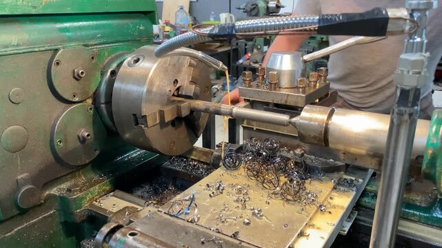 Professional precision metal turning process using industrial lathe machinery to shape steel rods with coolant application for efficient material removal and manufacturing tasks